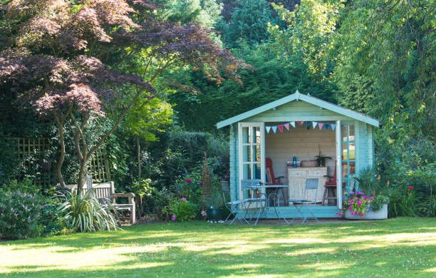 Cabane en bois au fond du jardin d'une maison