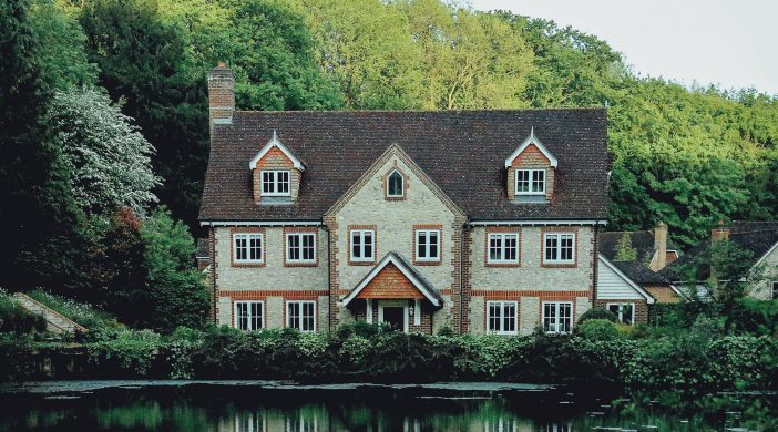 Grande maison devant de l'eau, avec nature en fond